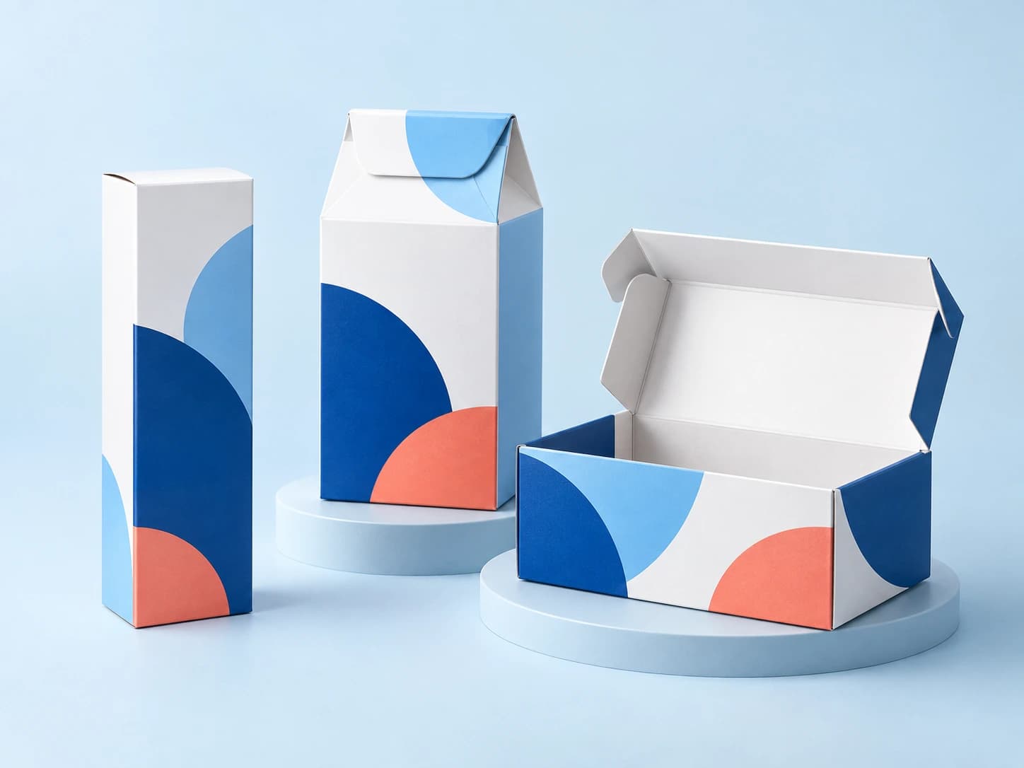 Drei individuelle Verpackungen aus weißem, blauem und korallfarbenem Karton