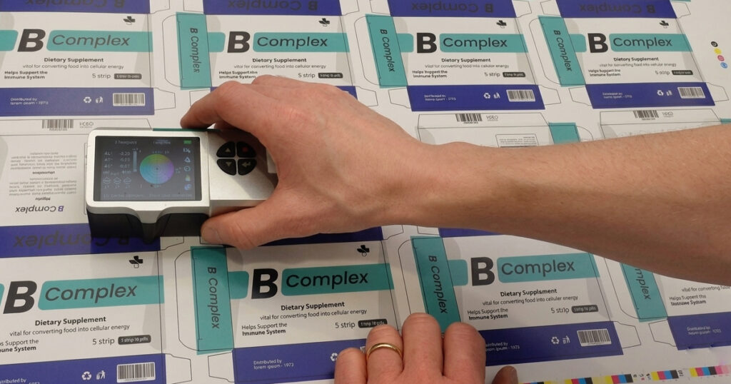 macchina di stampa digitale per packaging in funzione, con foglio di cartoncino in uscita
