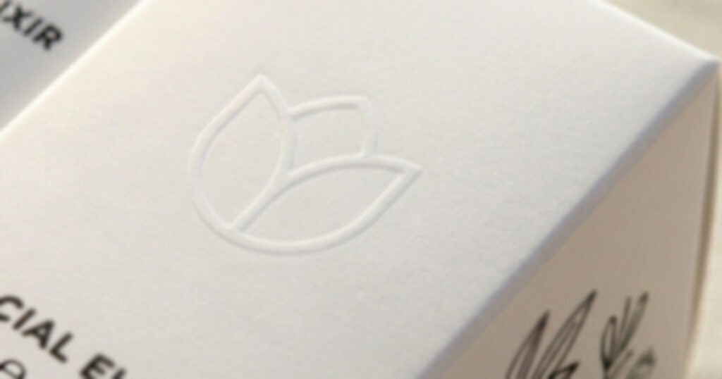 Logo in rilievo a secco (embossing) su cartoncino di un astuccio cosmetico